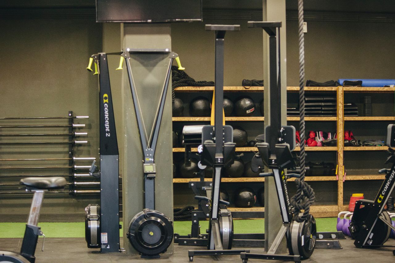 Rowing machines, weights, and training equipment inside a bright gym